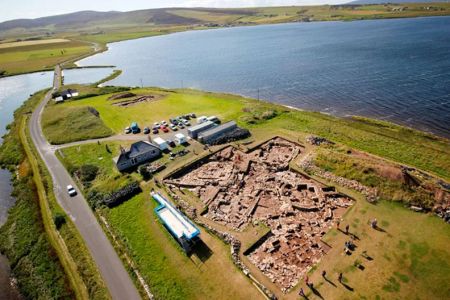 An aerial photograph of an archaeological excavation on a peninsula.
